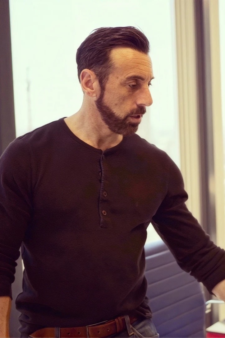 Craig Cecilio in a black Henley at his office desk